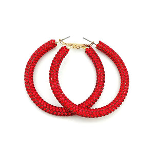 Close-up of red rhinestone hoop earrings with gold clasp, showcasing sparkling red stones on 2-inch hoops.